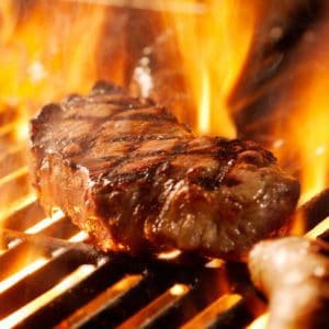 beef steak on the grill with flames